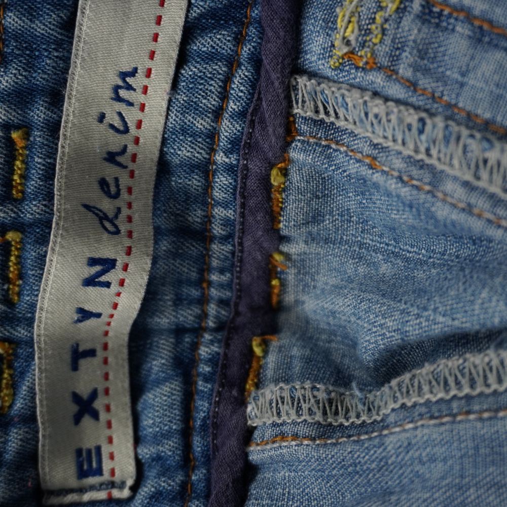  Etichetta d'archivio ricamata Extyn Denim in tessuto jacquard grigio e blu cucita all'interno della gonna.