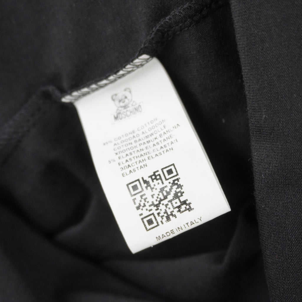 Vista dell'etichetta interna quadrata bianca dotata di codice QR e codice numerico per la verifica dell'originalità del capo.