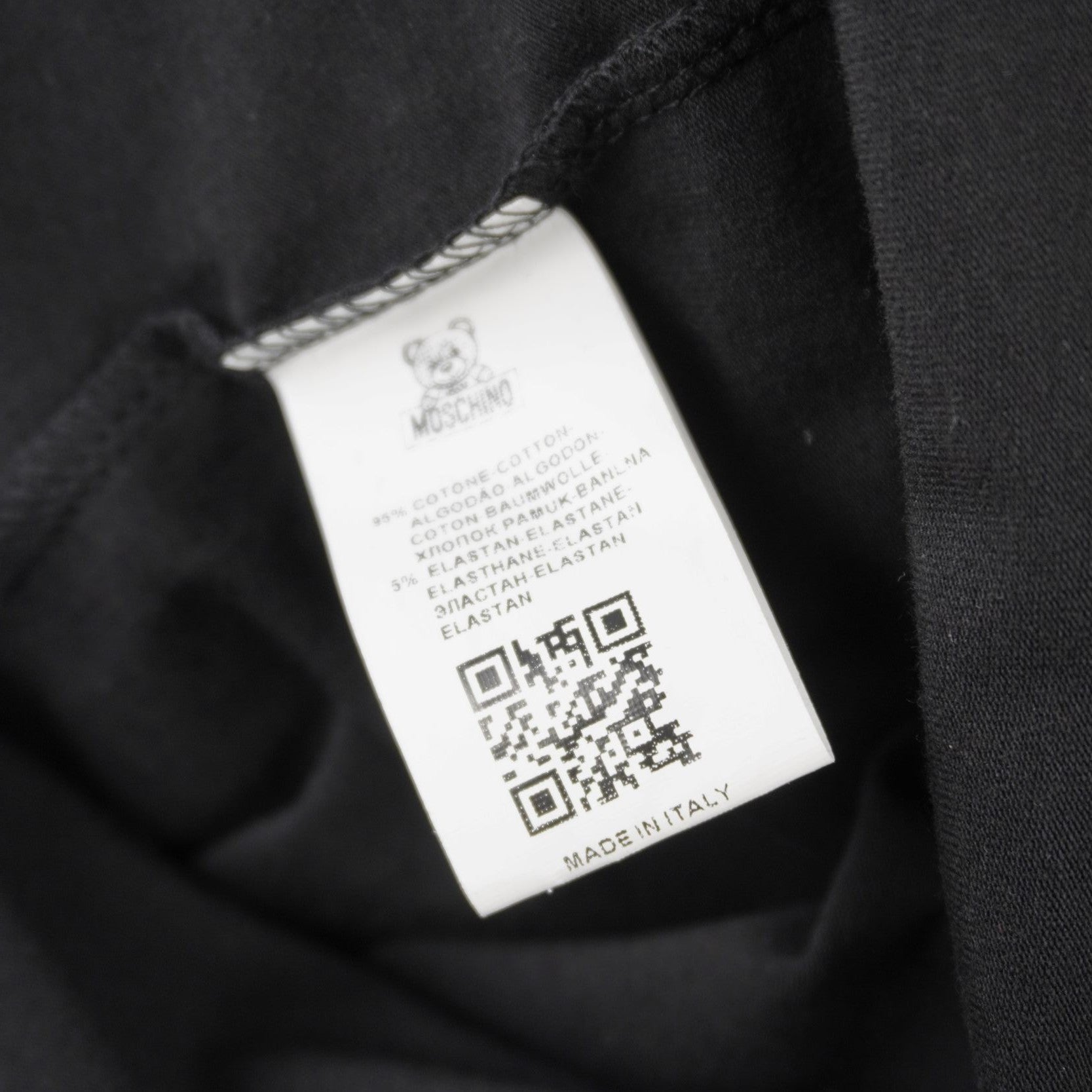 Vista dell'etichetta interna quadrata bianca dotata di codice QR e codice numerico per la verifica dell'originalità del capo.