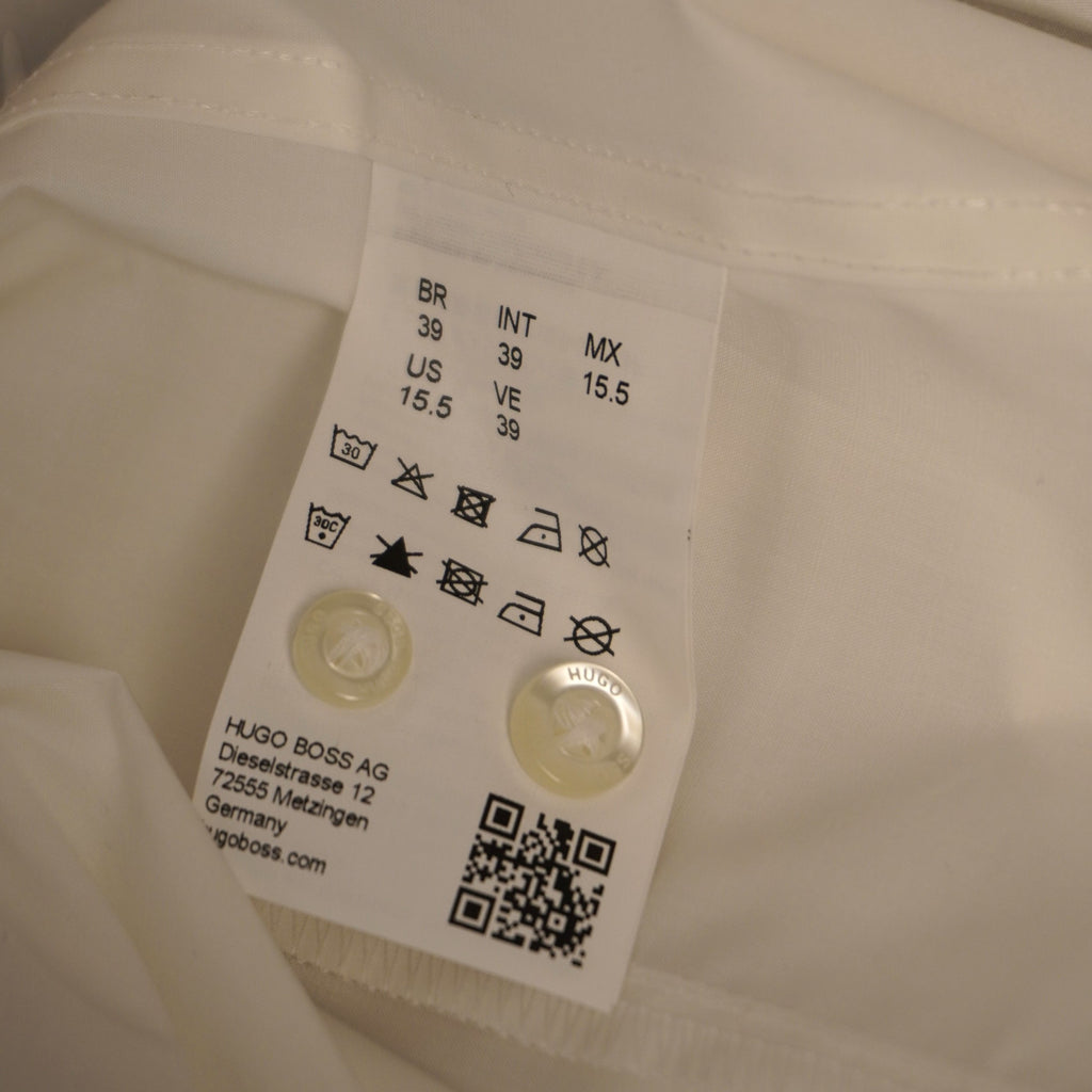  Inquadratura dell'etichetta interna in tessuto bianco stampata con i simboli di lavaggio e un codice QR per verificare l'originalità.