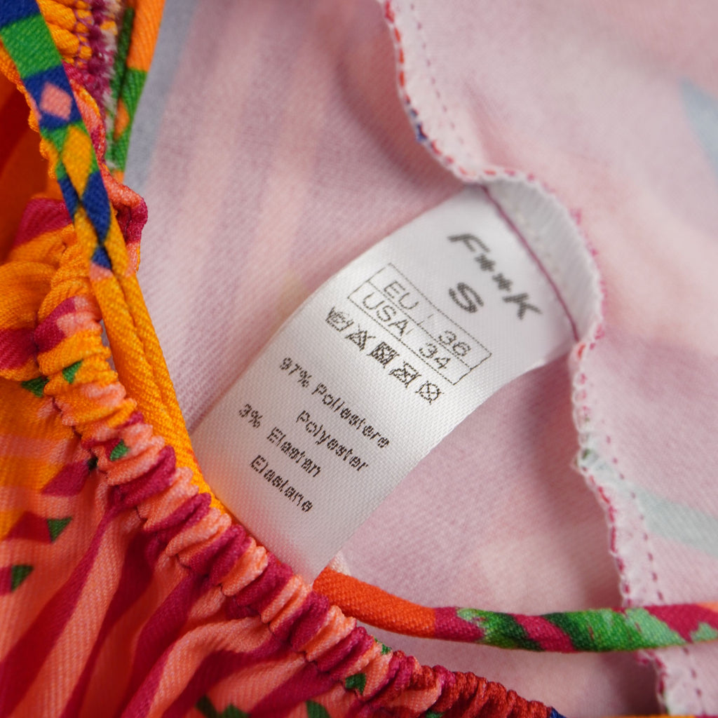 Etichetta interna di autenticità del vestito F**K con taglia S e composizione del tessuto