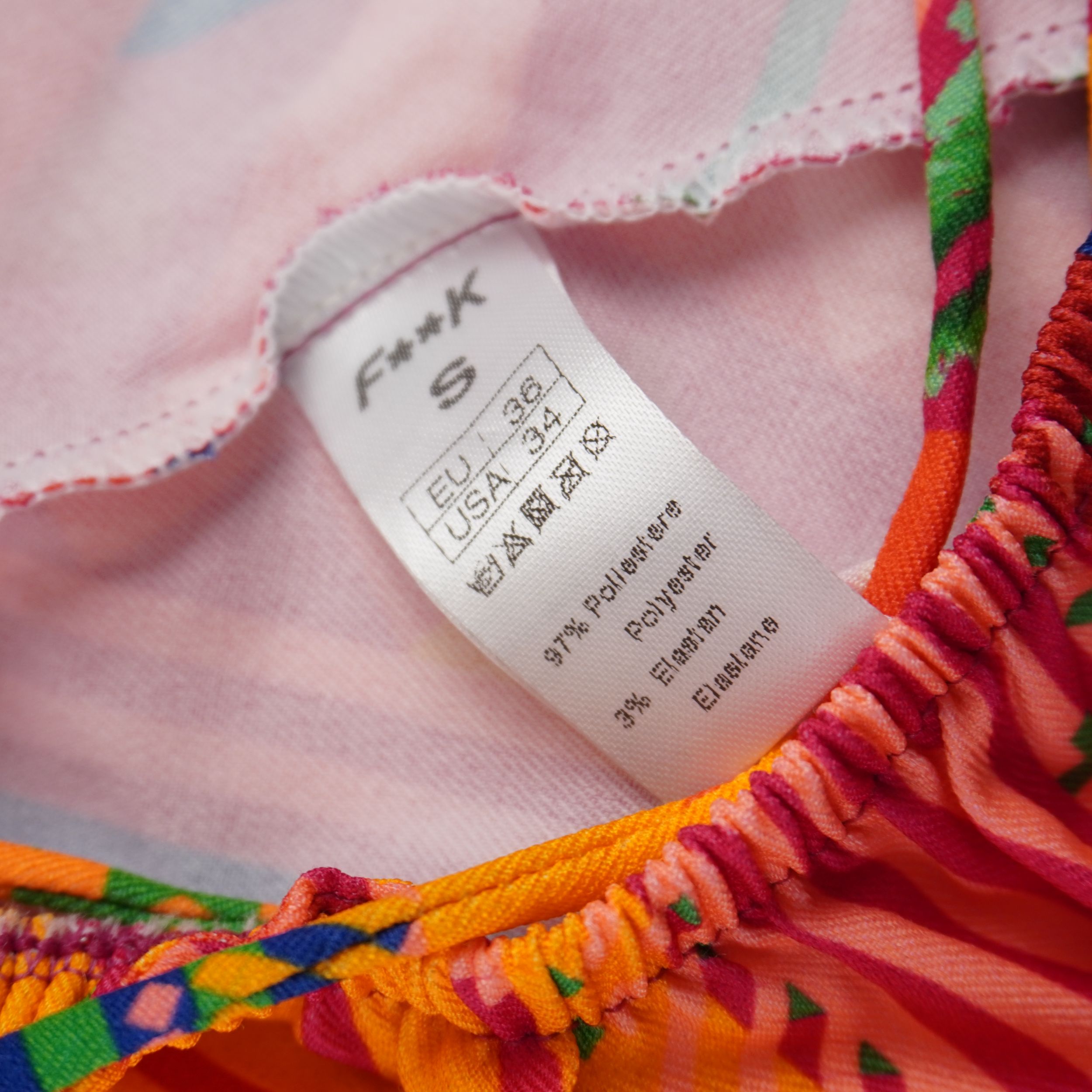 Etichetta interna di autenticità del vestito F**K con taglia S e composizione del tessuto