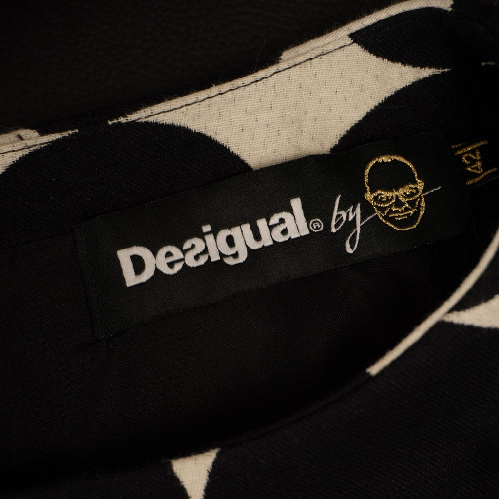 Dettaglio dell'etichetta interna nera ricamata con il logo Desigual by L., linea esclusiva in collaborazione con Christian Lacroix.