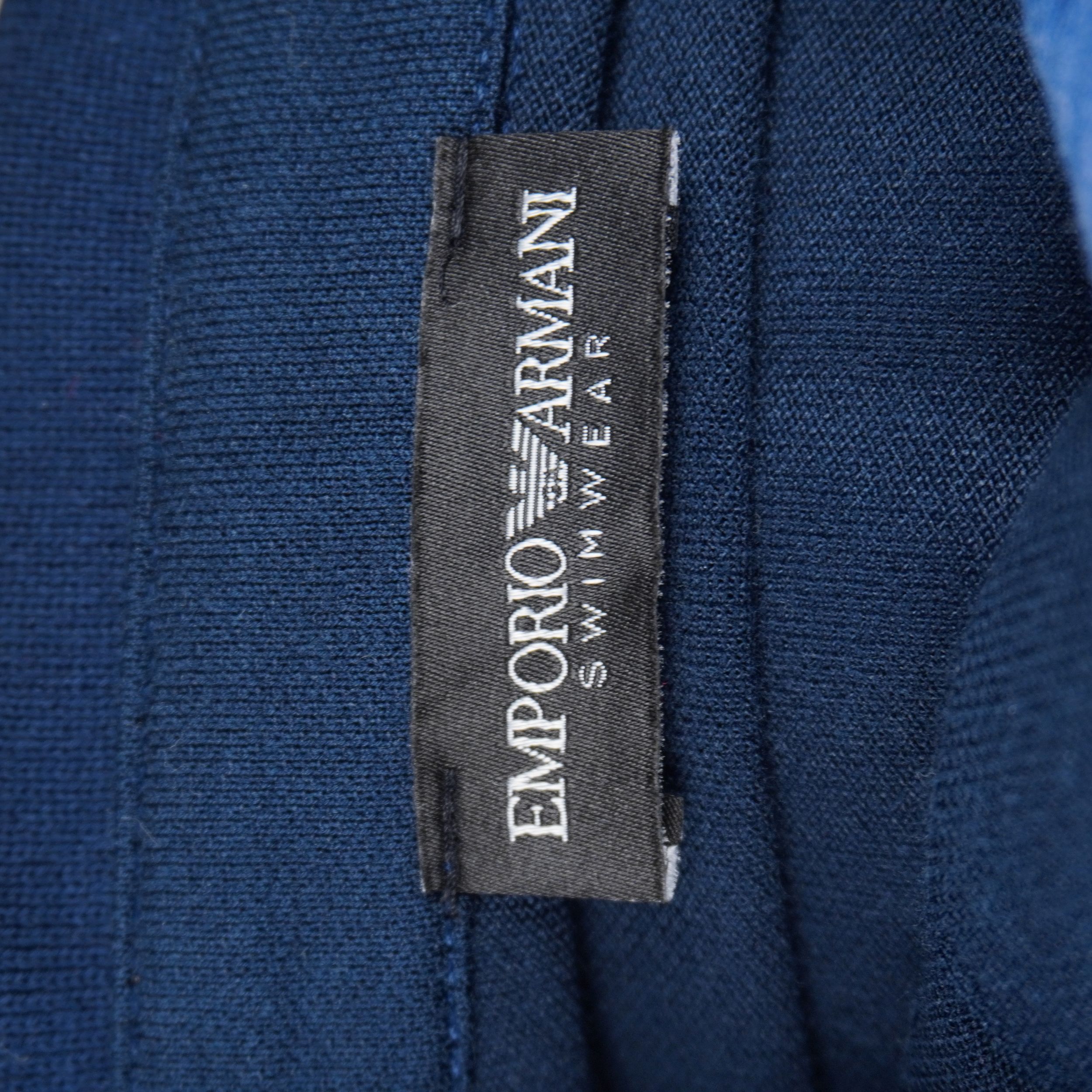 Dettaglio dell'etichetta interna nera ricamata con la scritta bianca Emporio Armani Swimwear per la certificazione della linea mare.