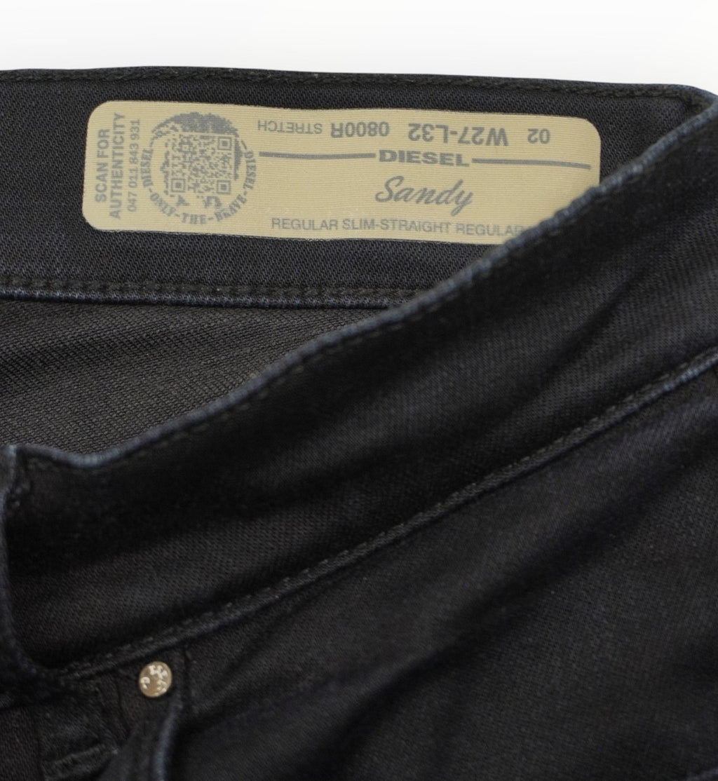 Particolare dell'etichetta beige ricamata cucita all'interno del fascione posteriore della vita dei jeans Diesel.
