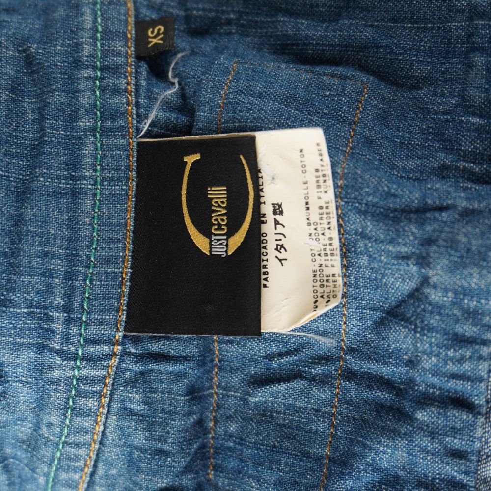 Etichetta interna Just Cavalli in tessuto nero e oro con dicitura Fabricado en Italia