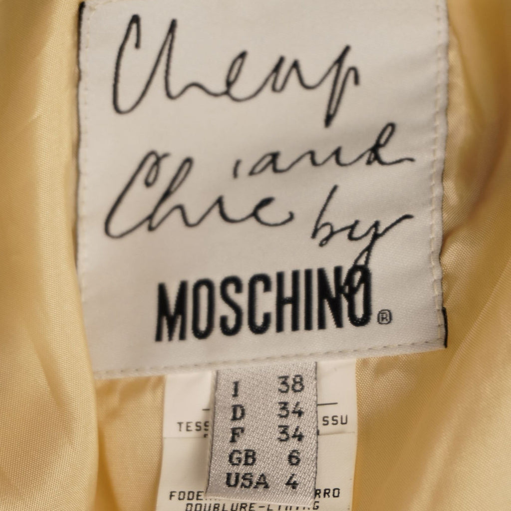 Primo piano dell'etichetta in tessuto bianco Cheap and Chic by Moschino con indicazione della taglia 38 IT.