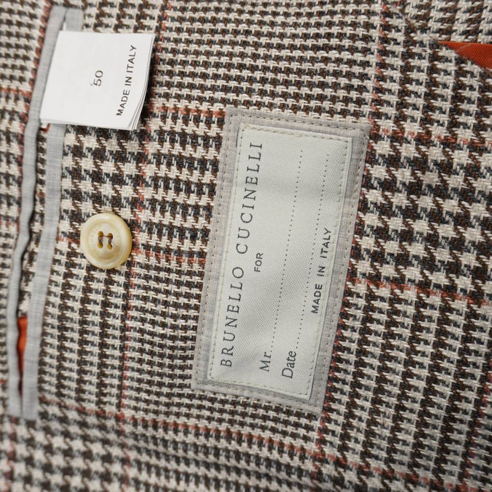 Etichetta interna sartoriale Brunello Cucinelli Made in Italy con cartellino della taglia 50 e bottone di cortesia.