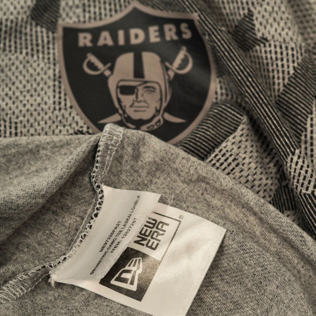 Dettaglio dello scollo interno che mostra l'etichetta nera stampata New Era e il logo dei Las Vegas Raiders cucito sul tessuto.