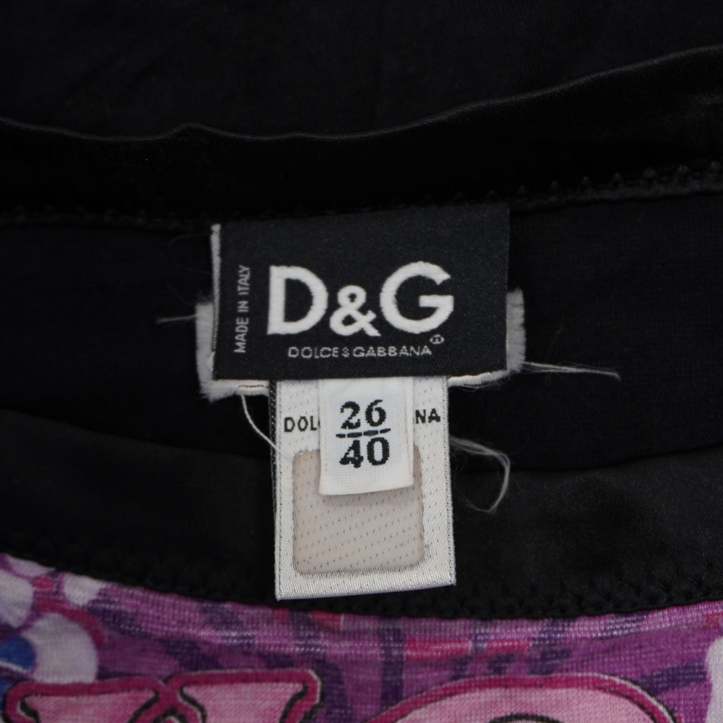 Primo piano del tag interno in tessuto nero D&G Dolce & Gabbana Made in Italy con indicazione della taglia 26 40.