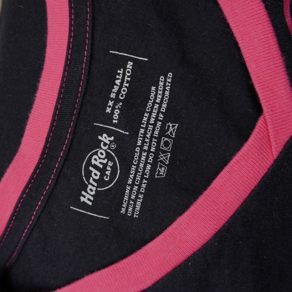 Etichetta interna stampata sul collo Hard Rock Cafe che mostra la taglia XX Small e la composizione 100% cotone