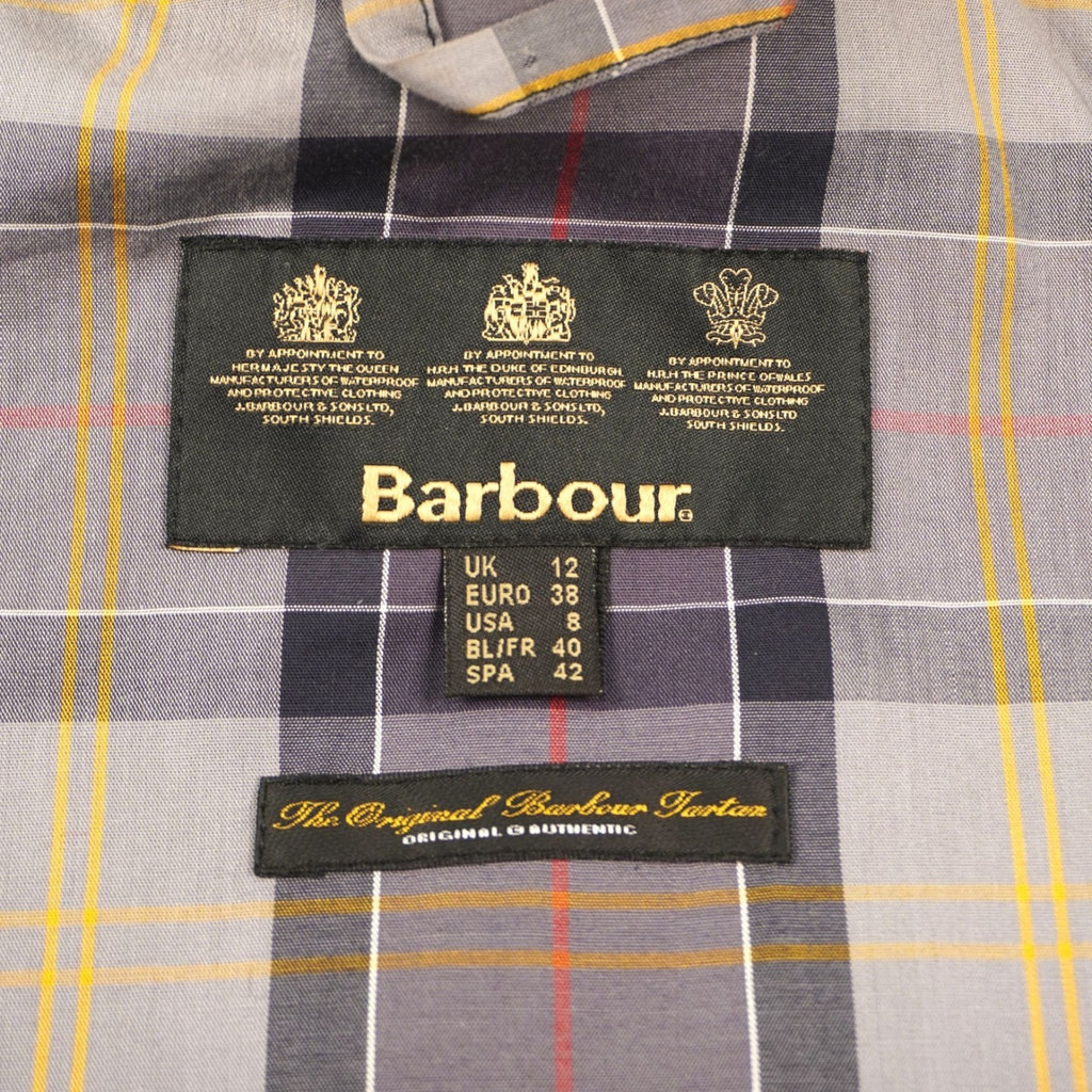 Dettaglio dell'etichetta interna d'archivio Barbour applicata sulla classica fodera in tessuto scozzese tartan.