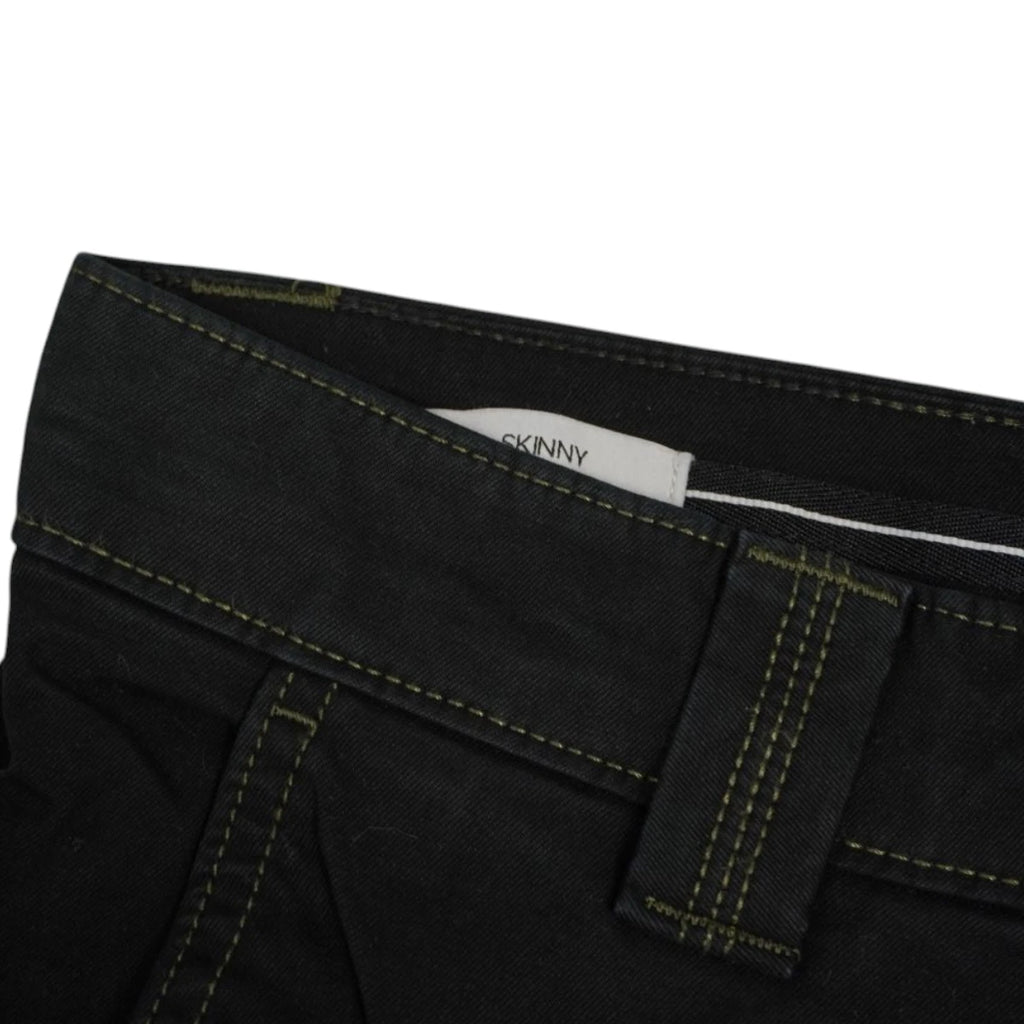Dettaglio della targhetta interna Skinny ricamata sul profilo della vita dei pantaloni neri