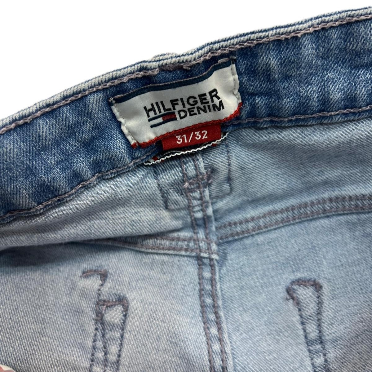  Etichetta in tessuto Hilfiger Denim cucita all'interno della vita posteriore del jeans con indicazione della taglia.