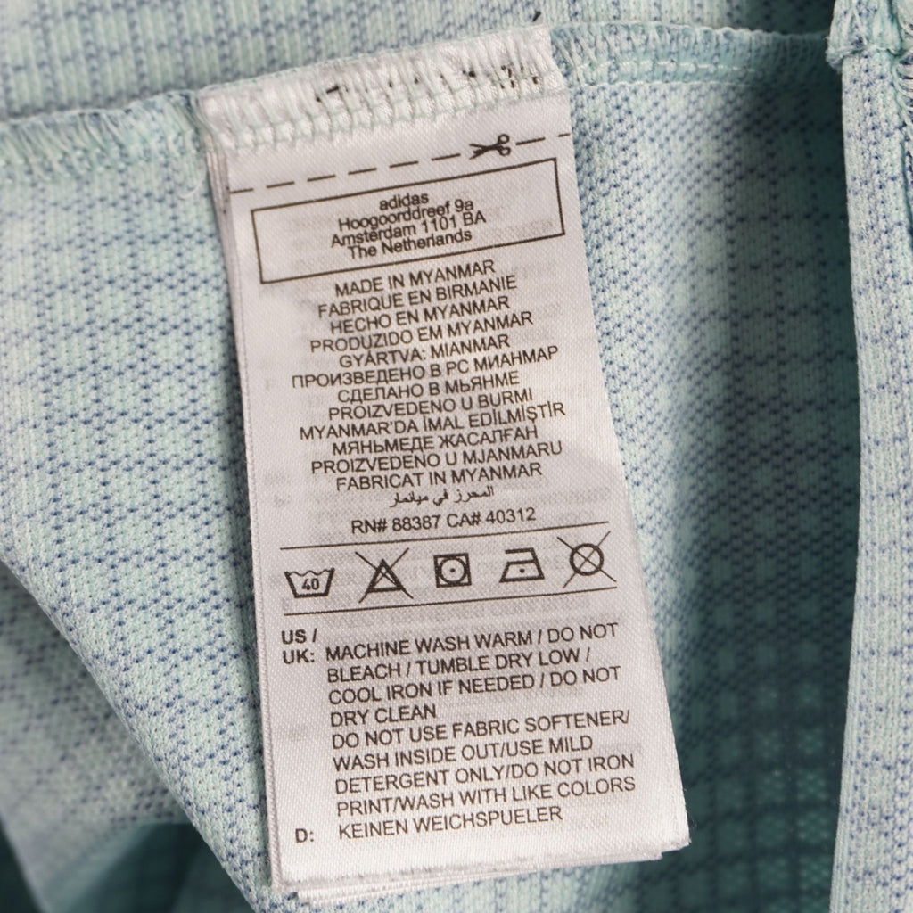 Etichetta interna in tessuto con i simboli di lavaggio a 40 gradi e le avvertenze per la cura della t-shirt adidas.