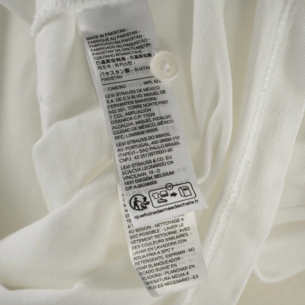 Inquadratura dell'etichetta di lavaggio con i dati delle sedi legali globali Levi Strauss e il logo Triman per il riciclo.