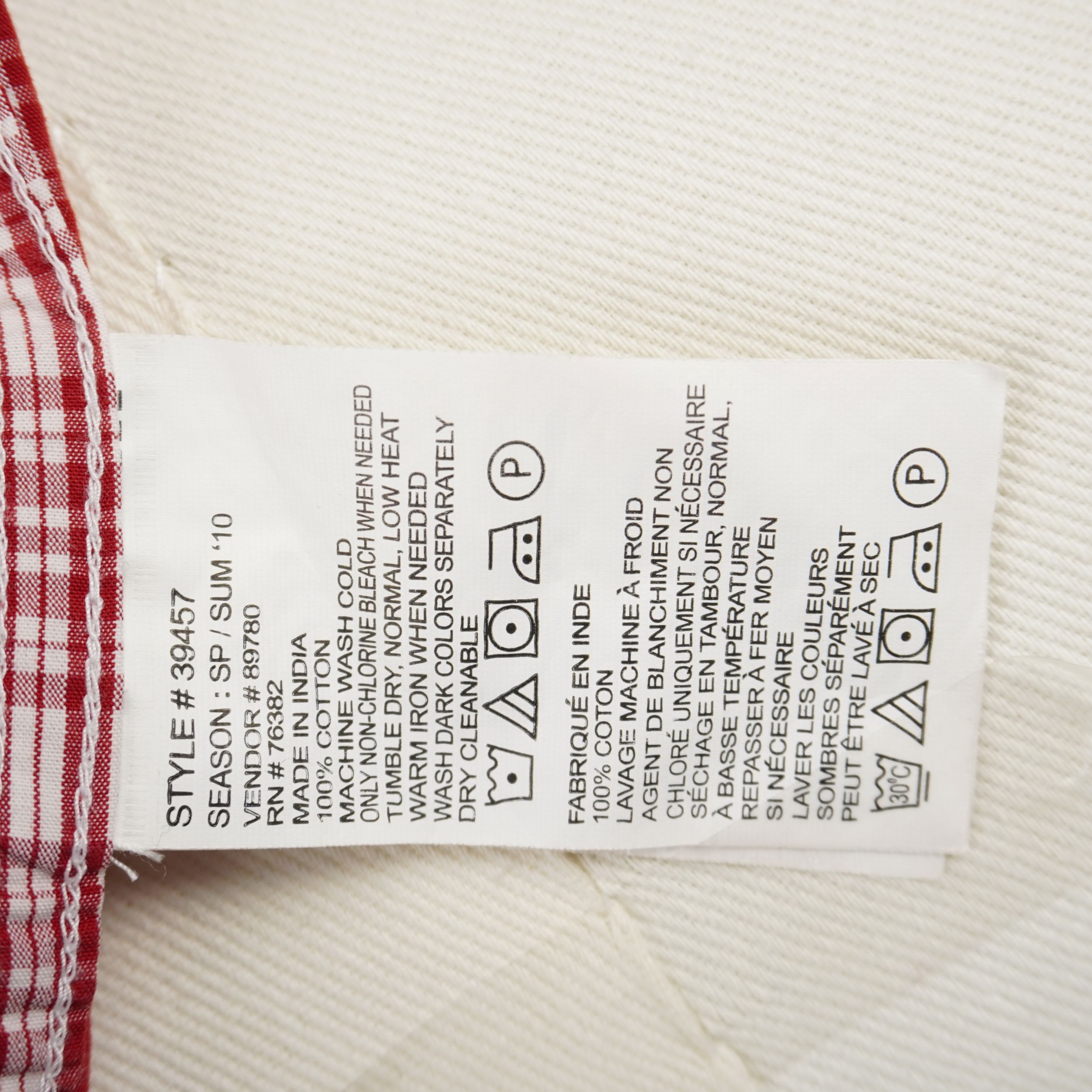 Etichetta tecnica interna bianca con codice modello Style 39457, stagione Summer 10 e composizione 100% cotone.