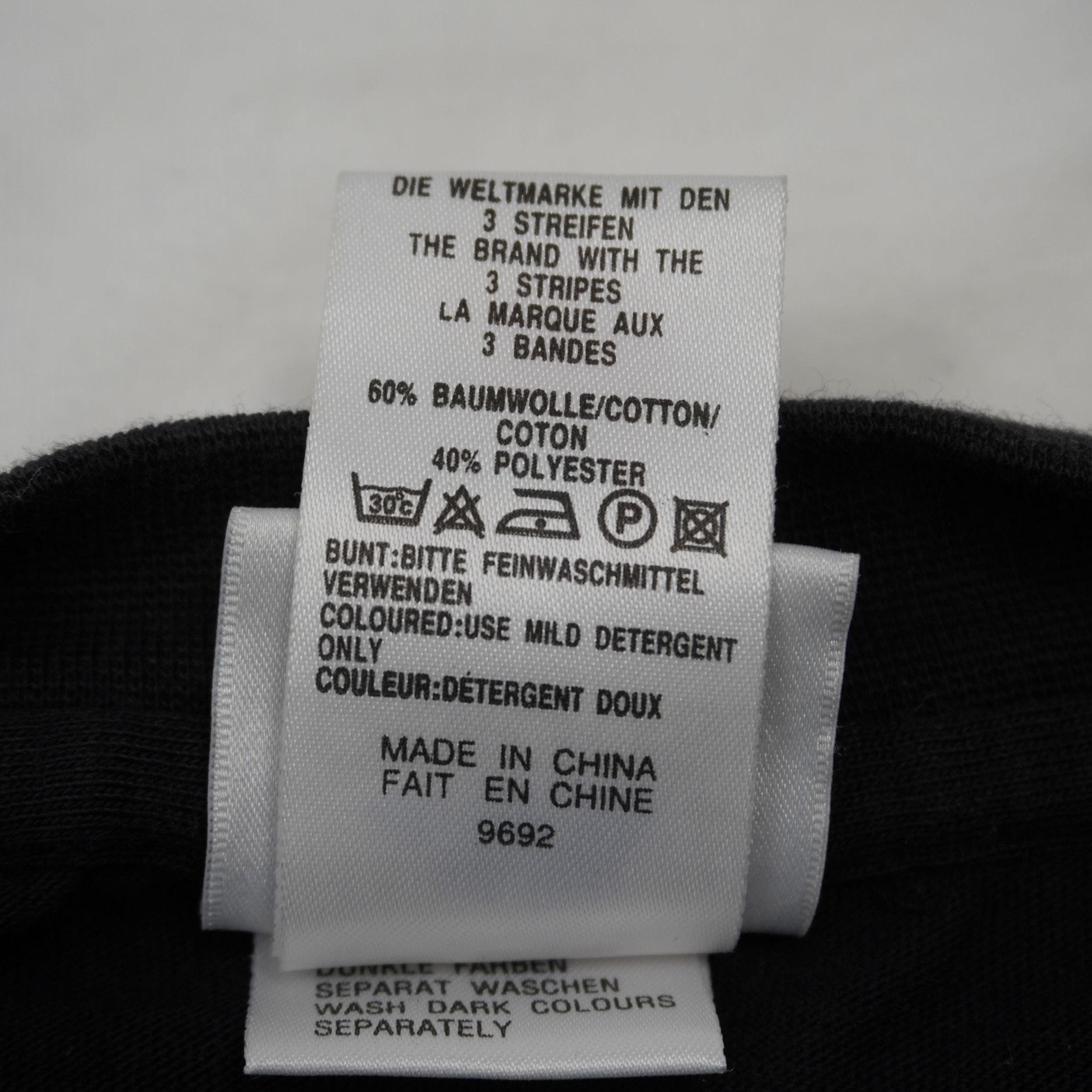 Retro dell'etichetta di lavaggio Adidas con composizione 60% cotone e 40% poliestere e dicitura Made in China.