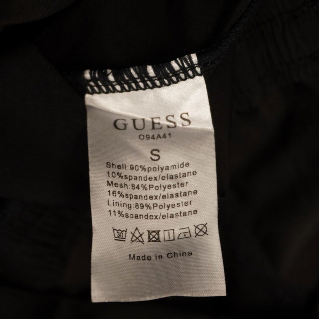  Etichetta interna bianca di manutenzione e lavaggio originale Guess con simboli e istruzioni.