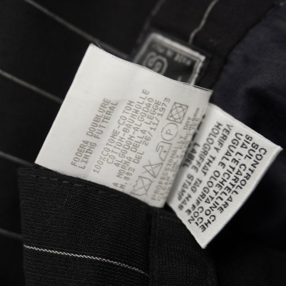 Etichetta interna di lavaggio dei pantaloni Versus Ittierre che indica la composizione in 100% Pura Lana Vergine.