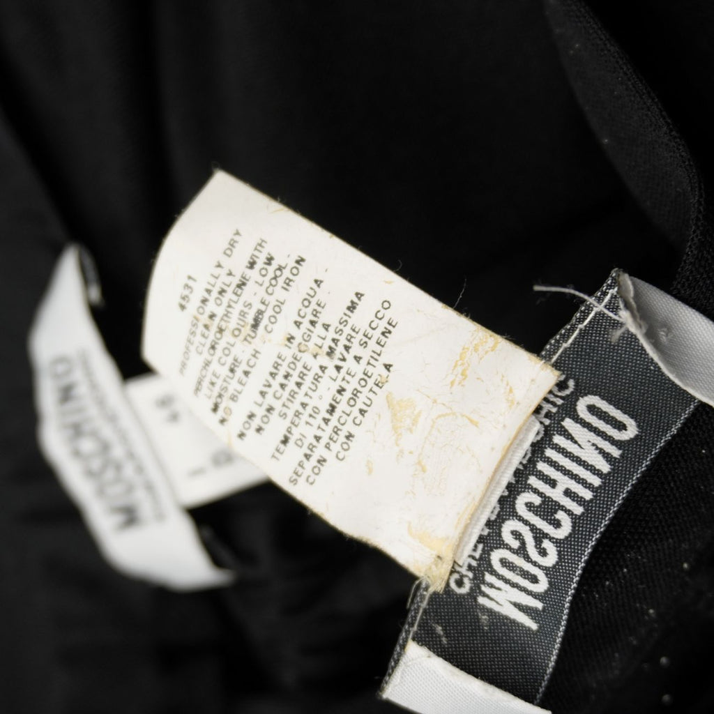 Dettaglio etichetta interna con istruzioni per il lavaggio a secco del completo Moschino.