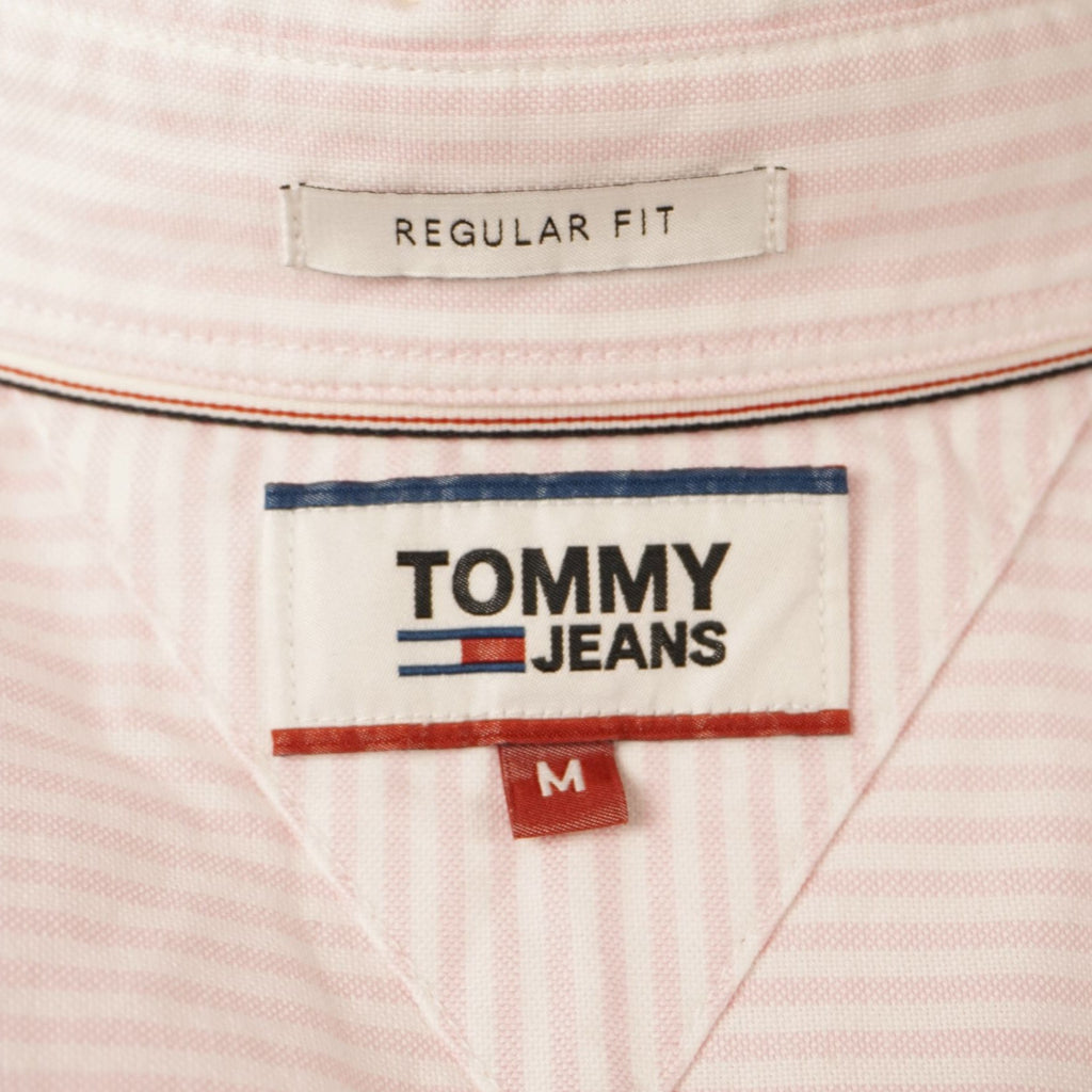 Dettaglio dell'etichetta interna rettangolare bianca Tommy Jeans con indicazione della taglia M.