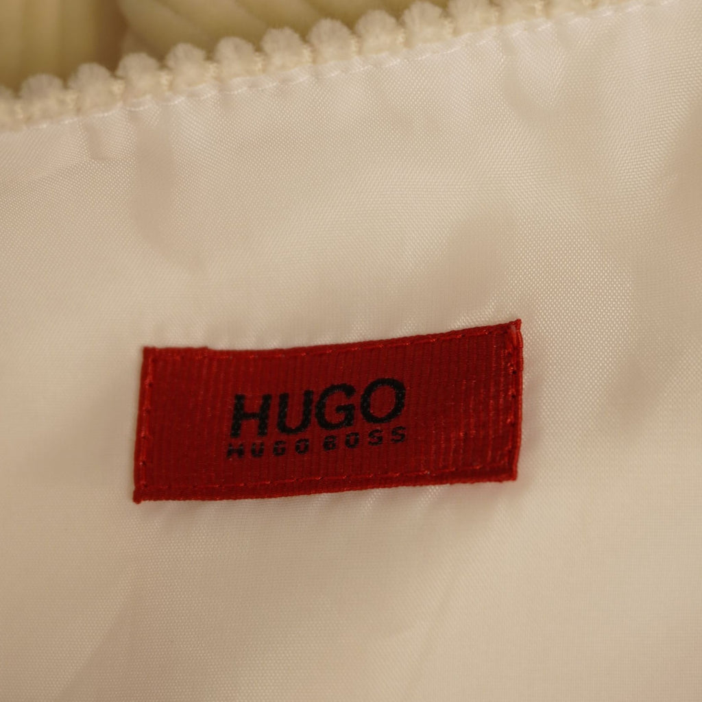 Dettaglio dell'etichetta interna rettangolare di colore rosso con il logo nero HUGO ricamato.