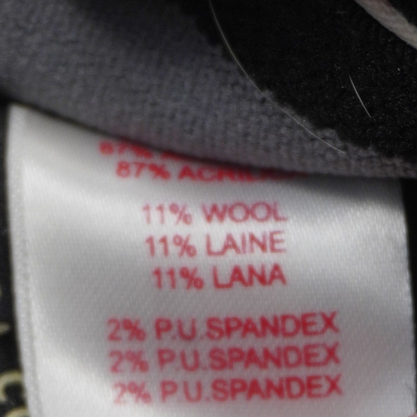 Dettaglio dell'etichetta interna con la composizione del tessuto (misto lana e fibre elasticizzate) per una vestibilità ottimale.