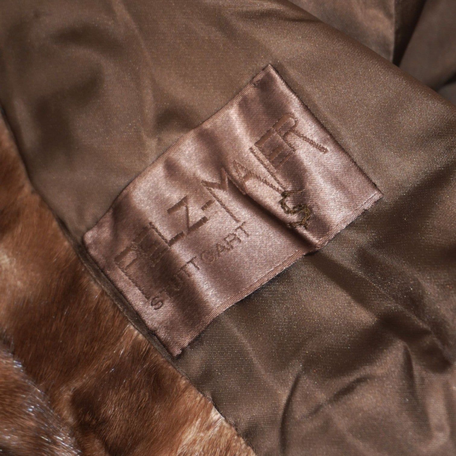  Etichetta sartoriale Pelz Maier Stuttgart ricamata sulla fodera interna marrone del cappotto vintage.