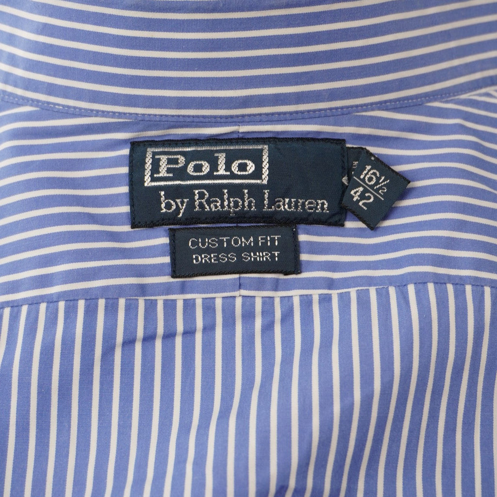 Dettaglio dell'etichetta interna blu scuro Polo by Ralph Lauren cucita sul colletto con l'indicazione della taglia XL.