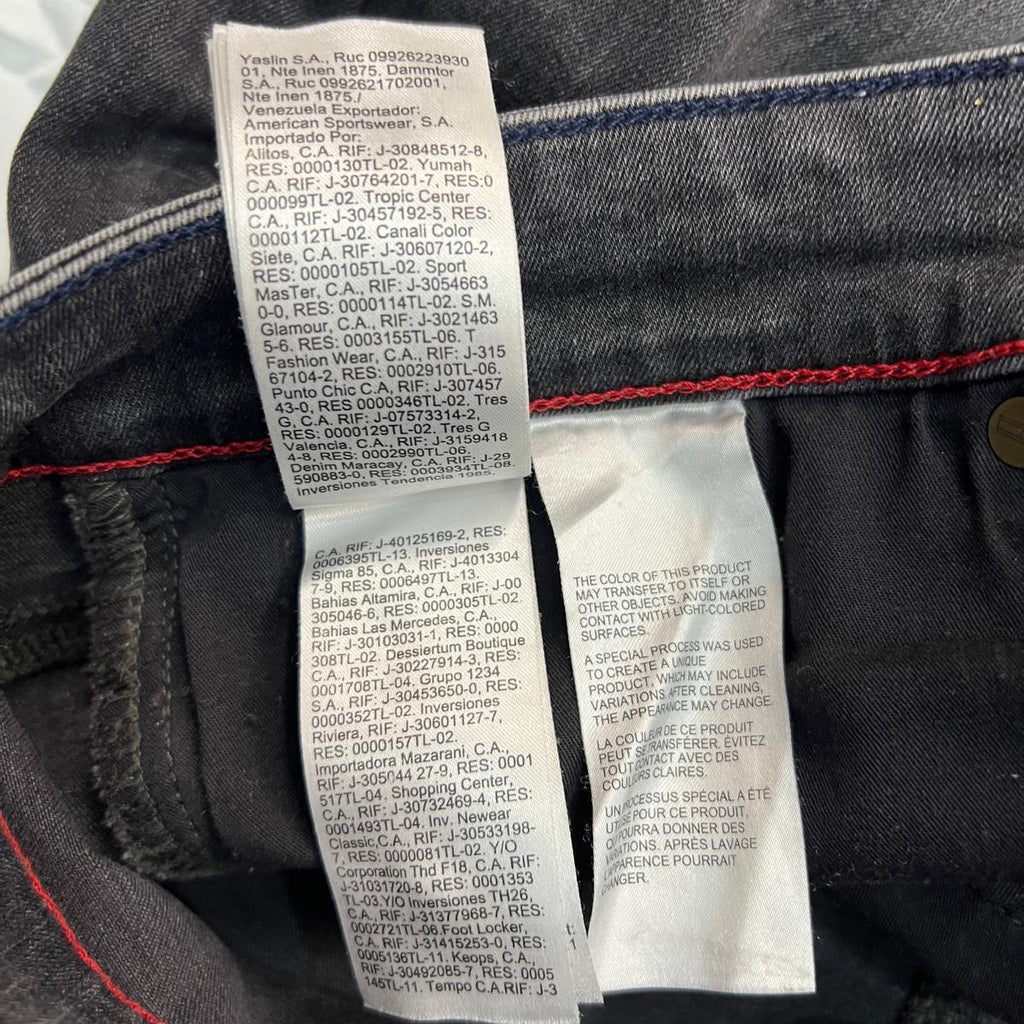 Dettaglio ravvicinato della sezione dell'etichetta che indica il mese e l'anno di produzione del jeans Tommy Jeans.