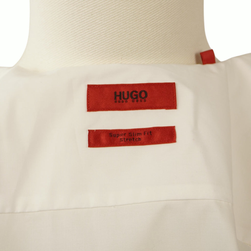Dettaglio interno del colletto aperto che mostra l'inconfondibile etichetta rossa rettangolare con il logo del brand HUGO.