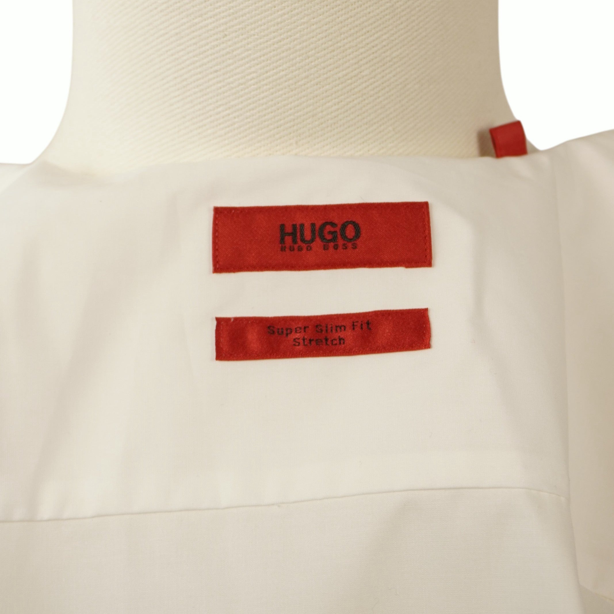 Dettaglio interno del colletto aperto che mostra l'inconfondibile etichetta rossa rettangolare con il logo del brand HUGO.