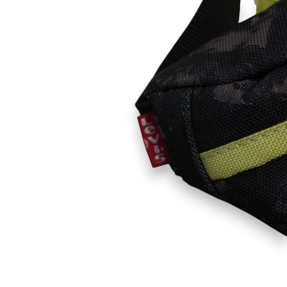 Zoom laterale sull'iconica etichetta in tessuto rosso Levi's Red Tab cucita sul fianco del marsupio mimetico.