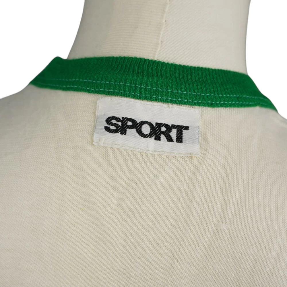 Dettaglio della label bianca con scritta nera SPORT applicata sul retro del colletto in maglia verde