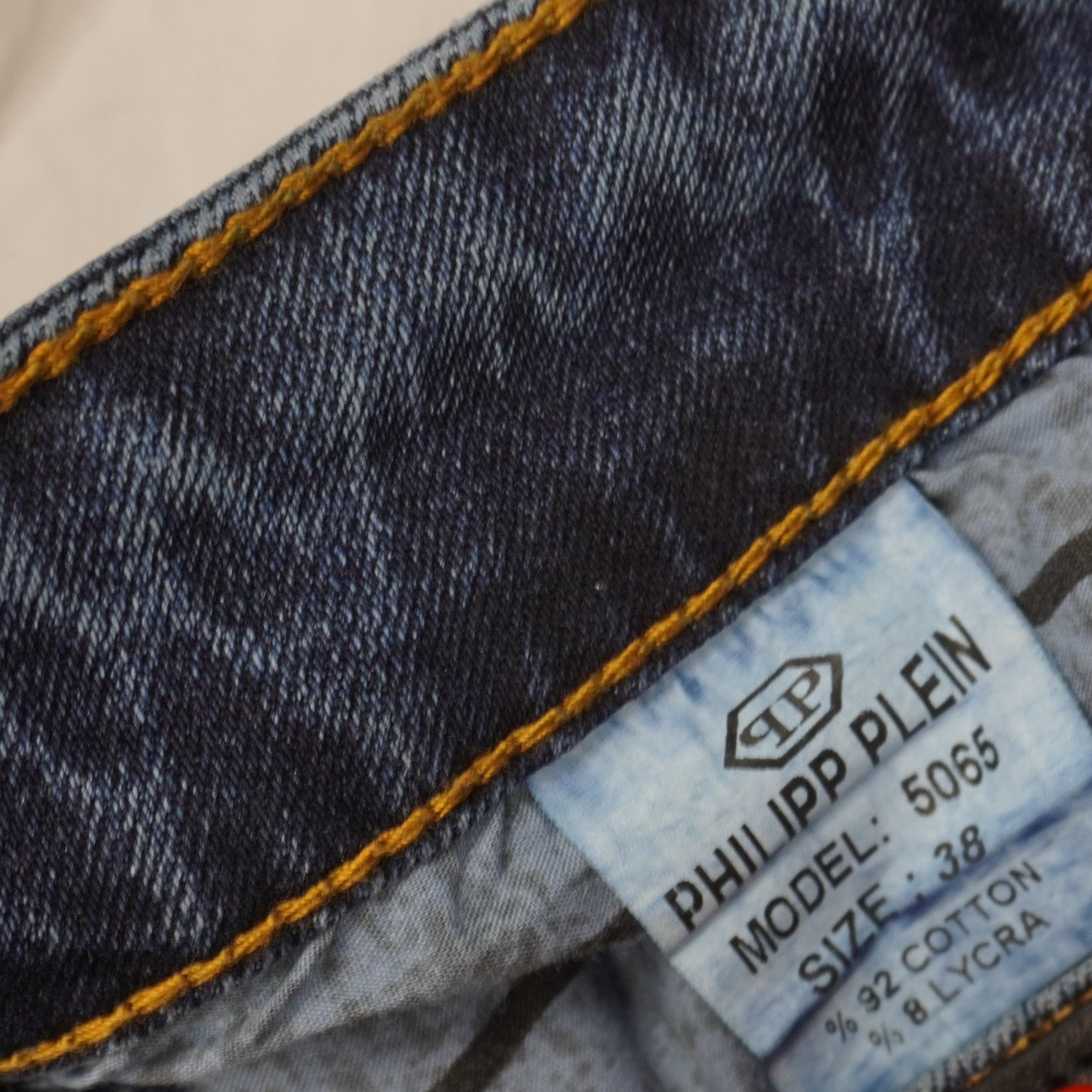 Primo piano macro dell'etichetta interna della composizione dei materiali con taglia uomo 38 e modello 5065