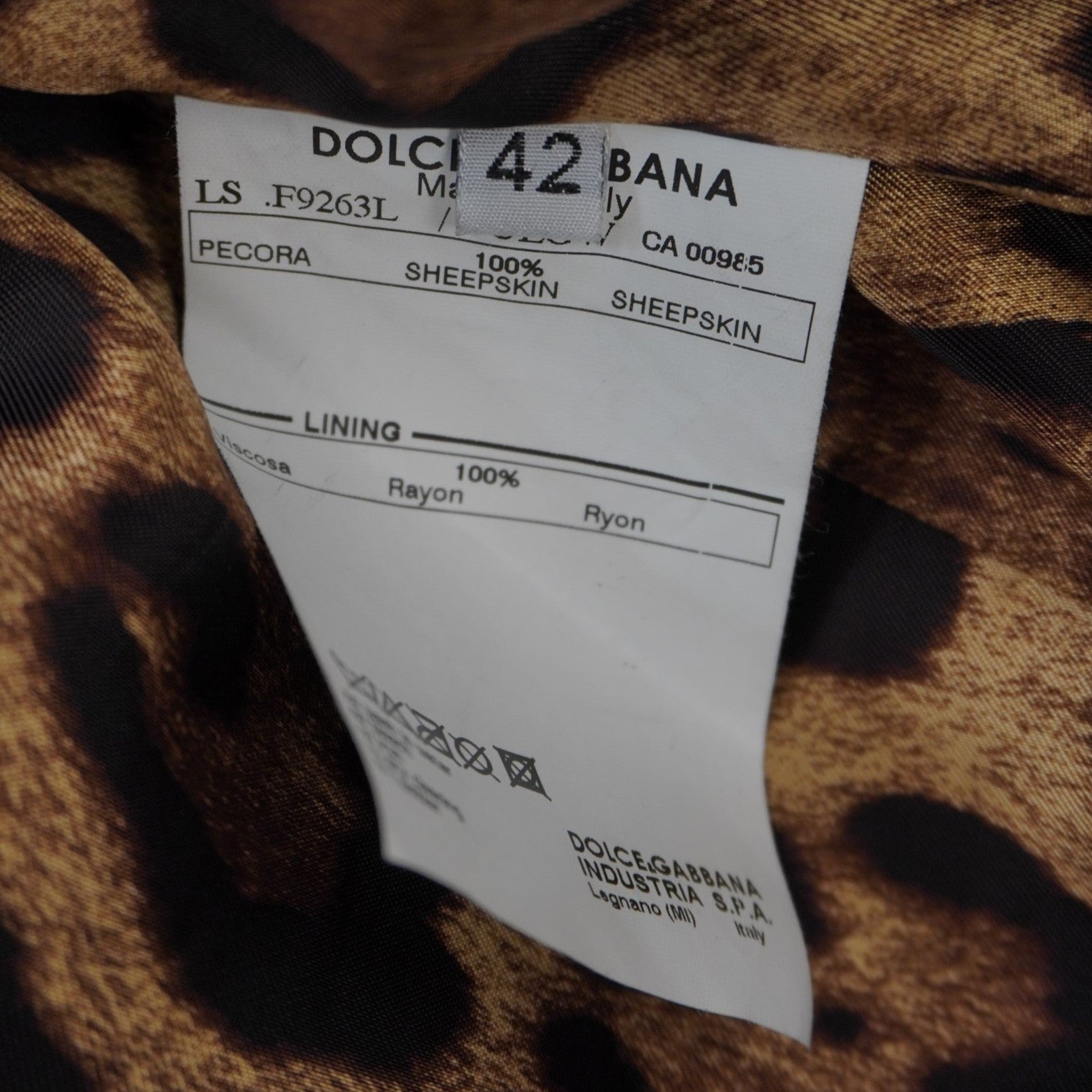Dettaglio del cartellino interno bianco che indica la taglia 42 italiana e la certificazione di produzione Dolce & Gabbana.