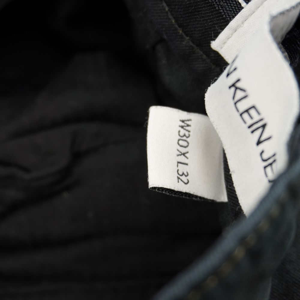 Etichetta interna della taglia W30 L32 corrispondente alla taglia 44 italiana su pantaloni Calvin Klein Jeans