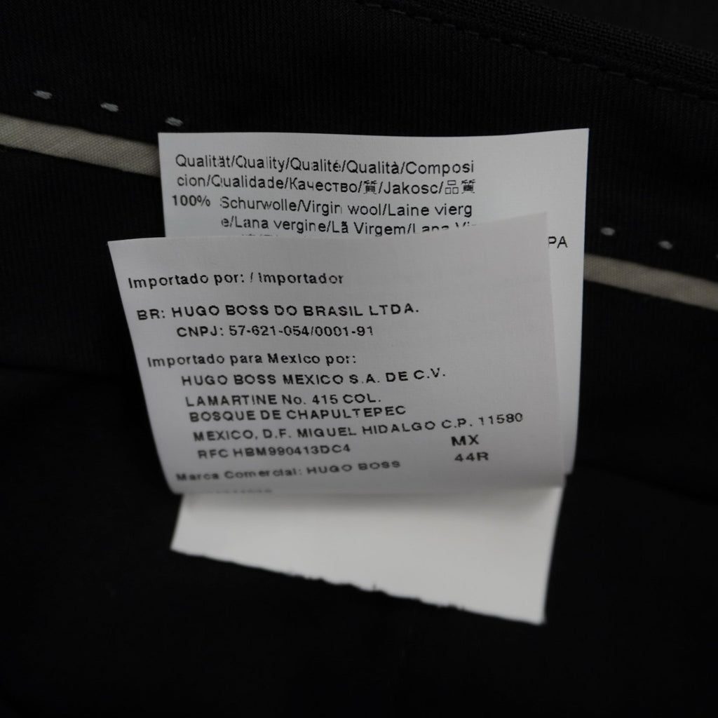 Macro dell'etichetta tecnica in tessuto bianco recante l'indicazione della taglia italiana 54 e la composizione in lana vergine.
