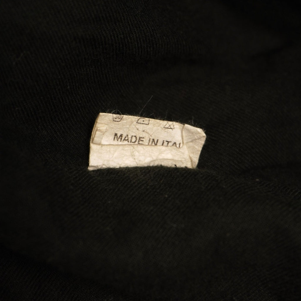 Primo piano della piccola etichetta interna bianca che indica la taglia S del blazer.