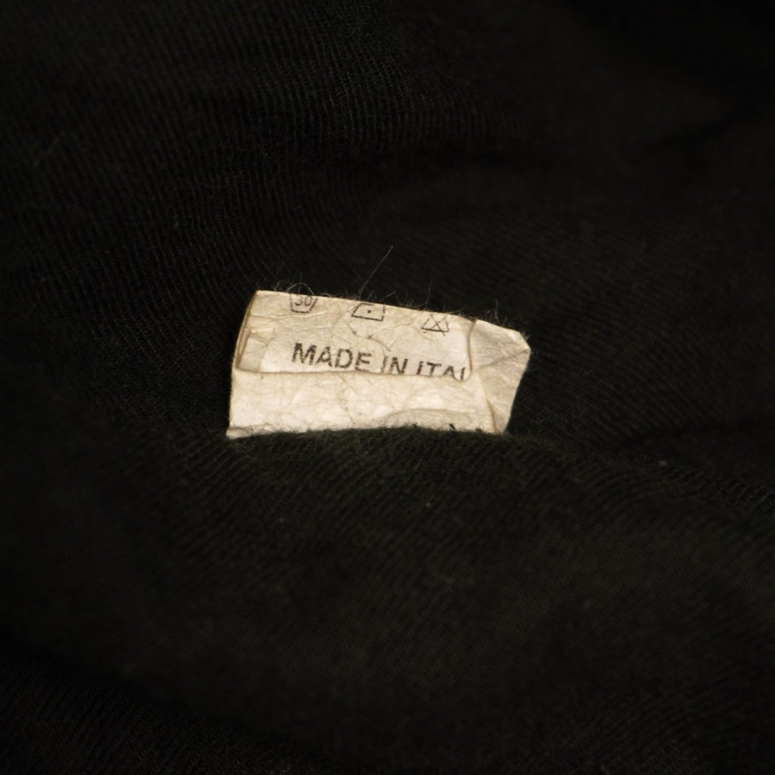 Primo piano della piccola etichetta interna bianca che indica la taglia S del blazer.