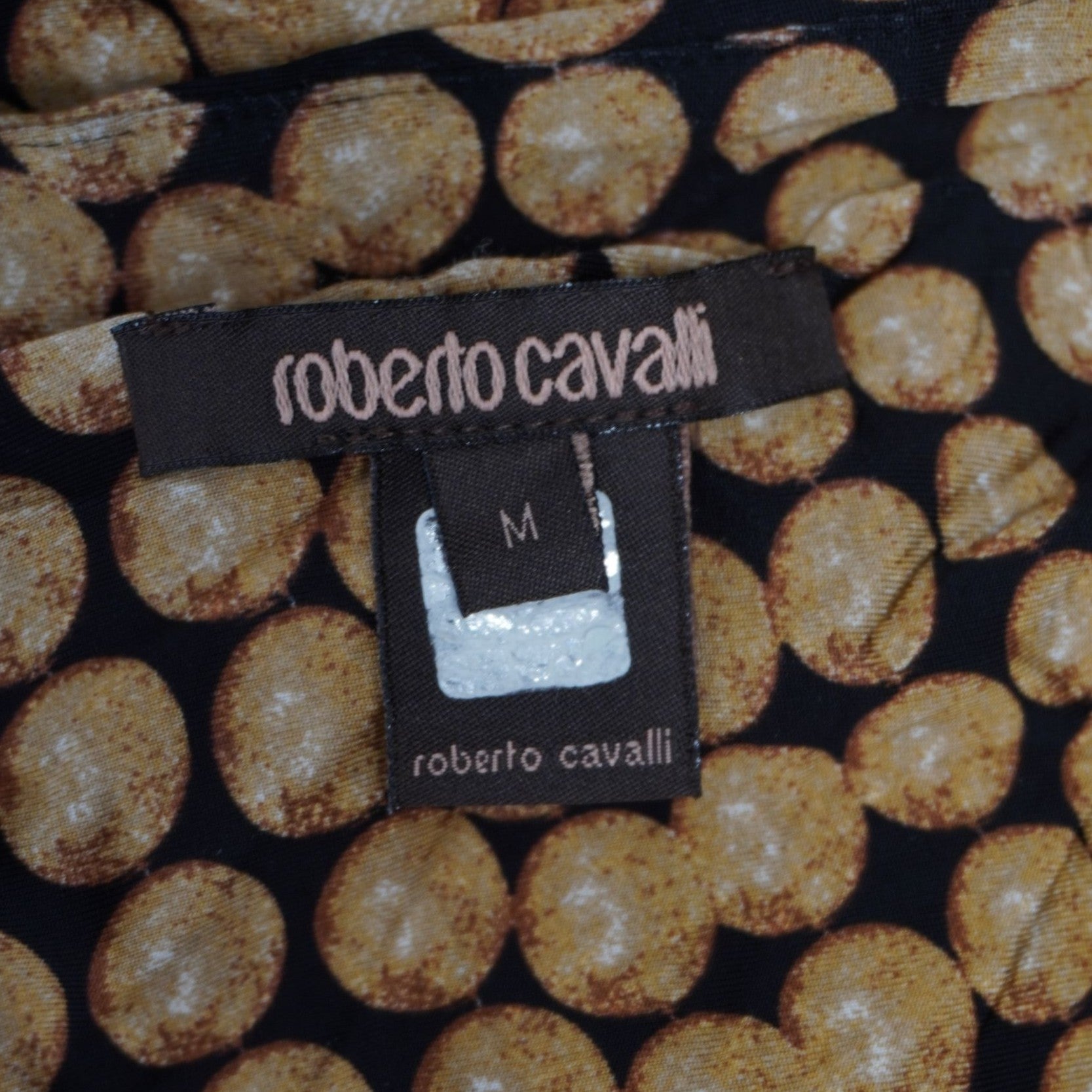 Primo piano della label istituzionale in tessuto nero Roberto Cavalli Main Line applicata sul retro del collo.