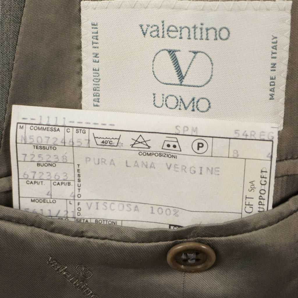 Dettaglio della tasca interna della giacca con l'etichetta ricamata Valentino Uomo e il cartellino di composizione bianco