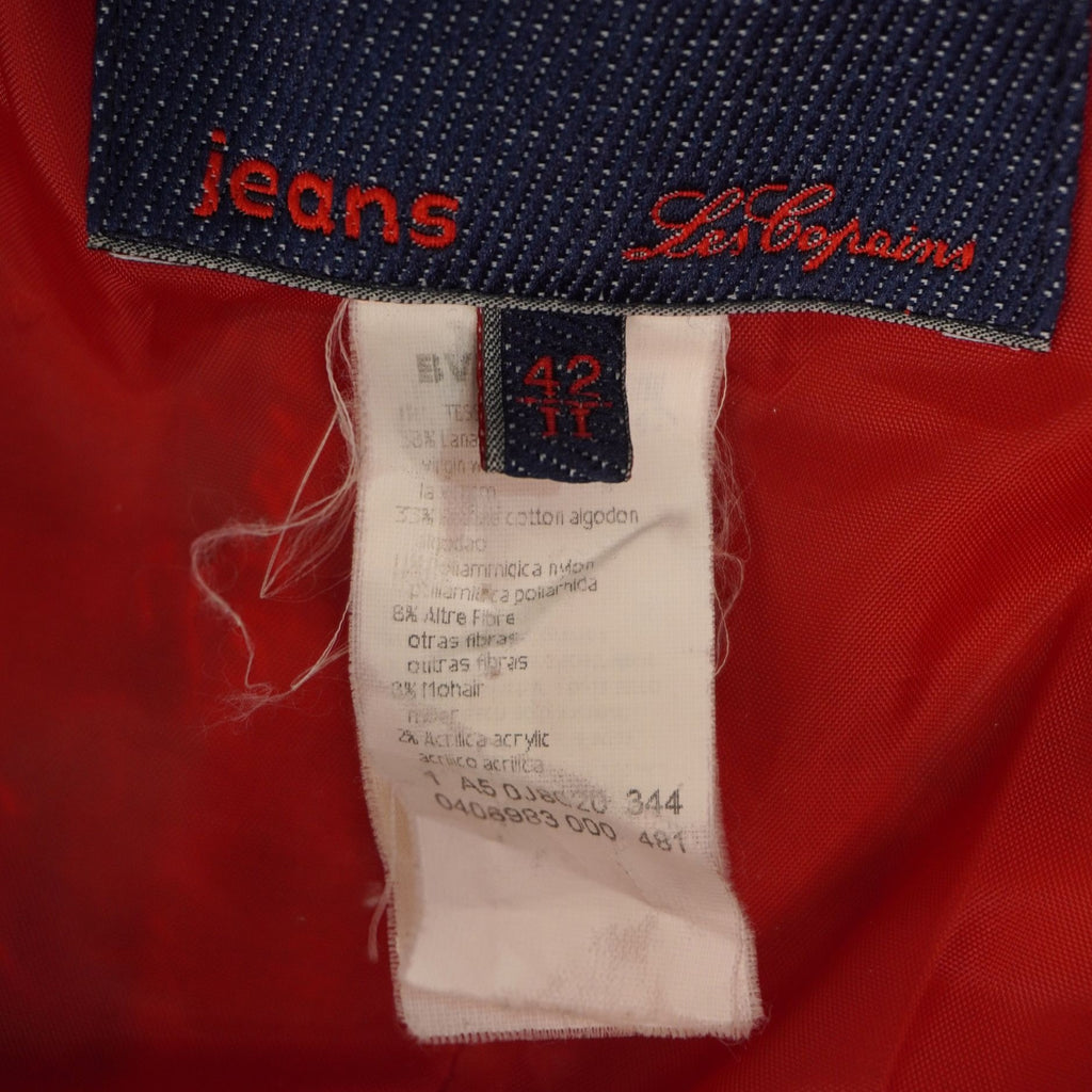 Vista interna del cappotto vintage Les Copains che mostra la fodera in tessuto rosso lucido e le etichette del brand.