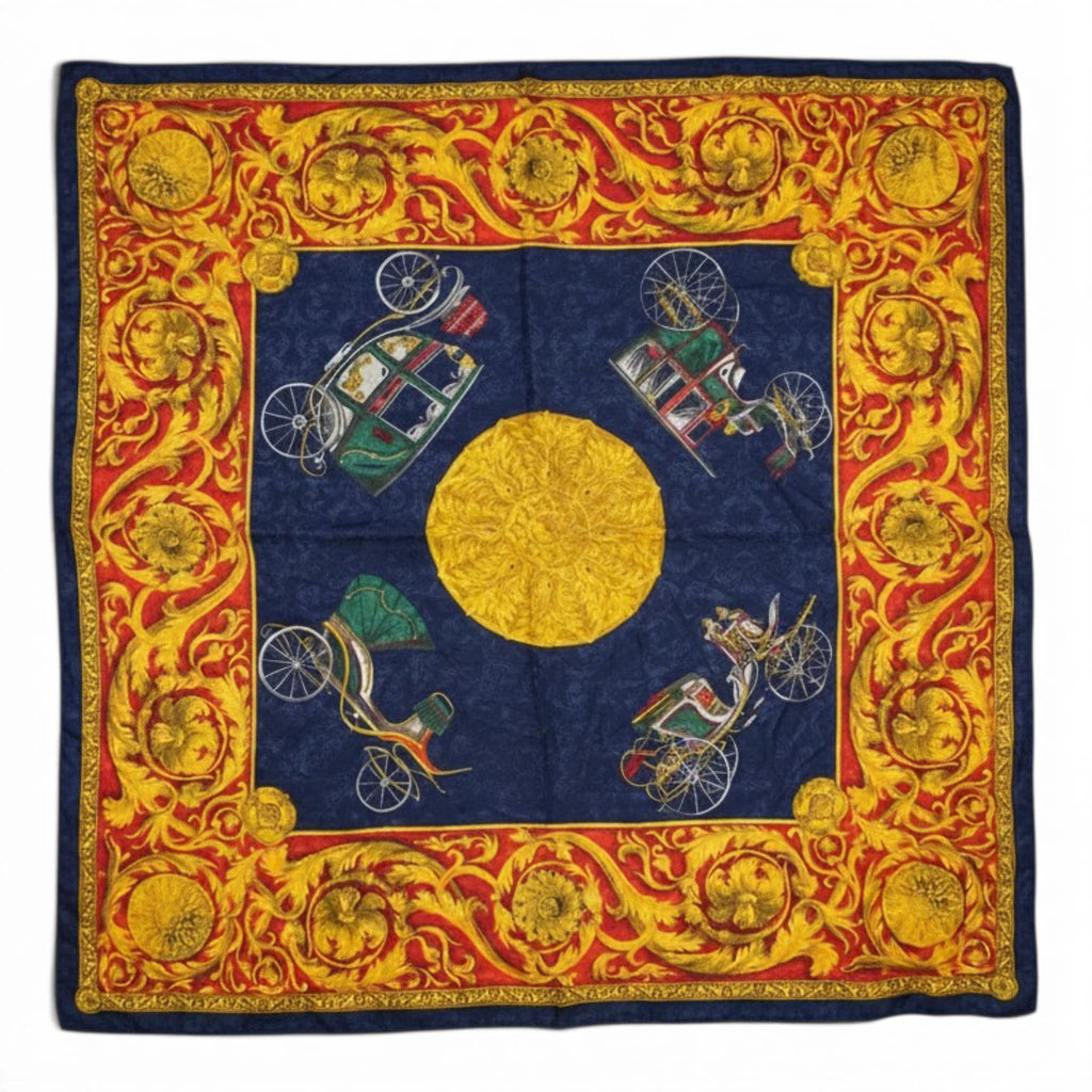 Vista d'insieme quadrata del foulard vintage Renato Balestra in seta con motivo barocco blu, rosso e oro, grande sole centrale e stampe di quattro carrozze d'epoca.