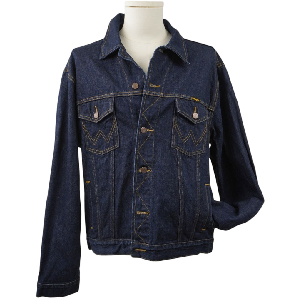 Vista frontale di una giacca di jeans Wrangler vintage color blu indaco scuro su manichino, con due tasche sul petto e cuciture color tabacco.