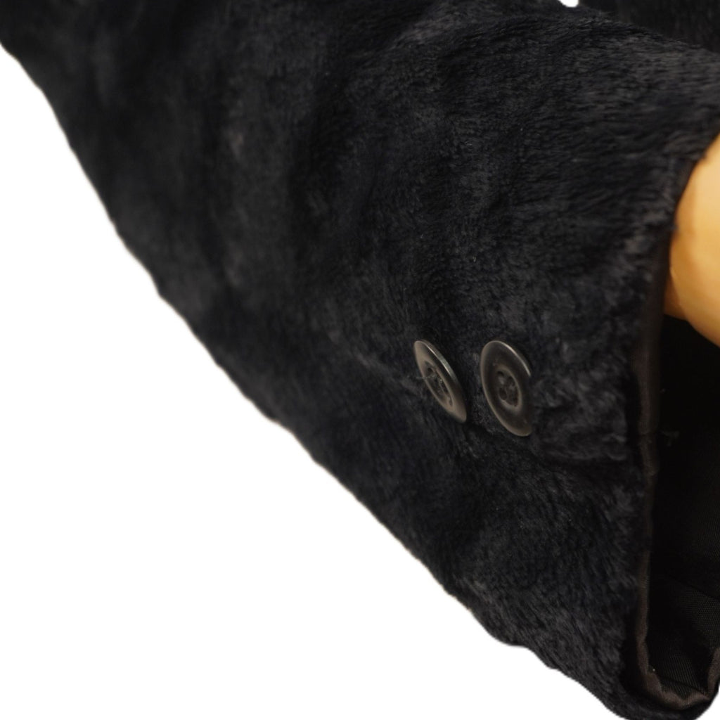  Inquadratura ravvicinata del fondo manica della giacca nera Angela Gavioli, che mostra la texture del tessuto materico operato.