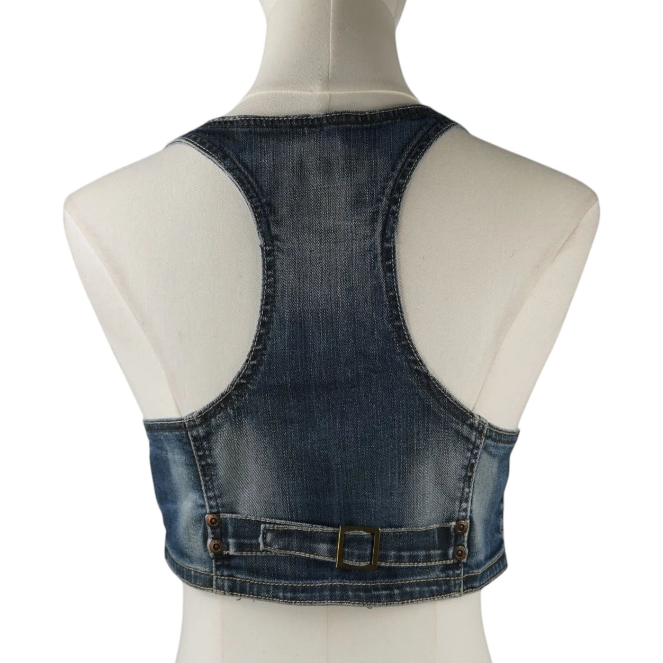 Vista posteriore del gilet in denim cropped Pimkie con taglio a vogatore e cinturino regolabile con fibbia metallica sul retro.