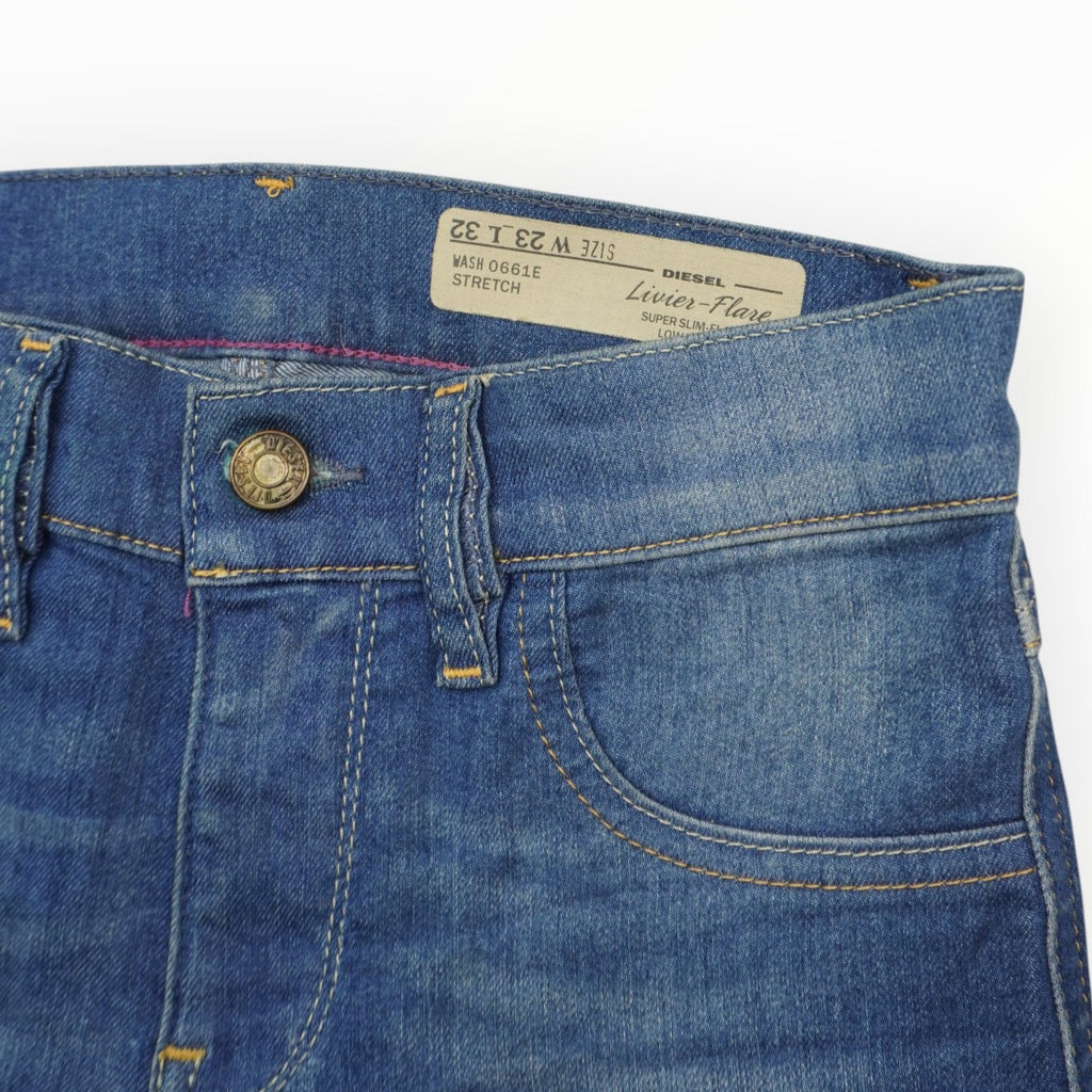 Inquadratura ravvicinata della vita frontale dei jeans Diesel con la caratteristica etichetta obliqua Industry Label sulla tasca portamonete.