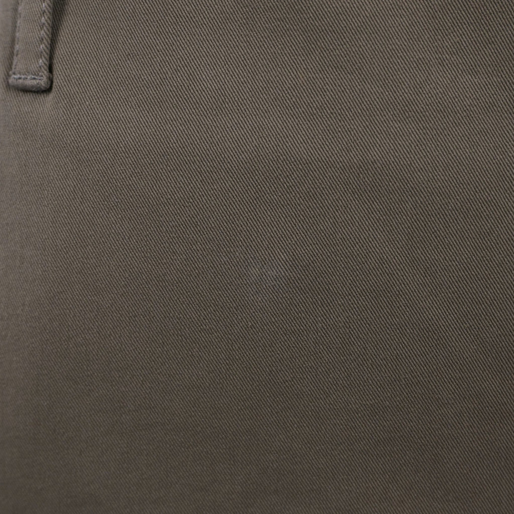 Particolare del tessuto in cotone stretch verde oliva che mostra la trama strutturata ed elasticizzata del capo